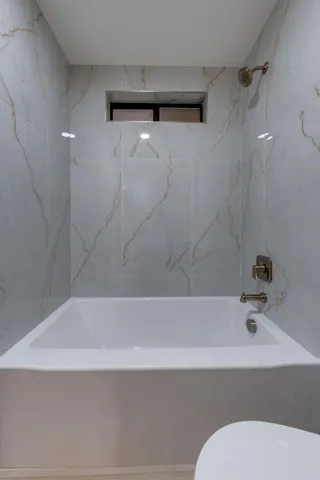 a bathroom with a bathtub and toilet