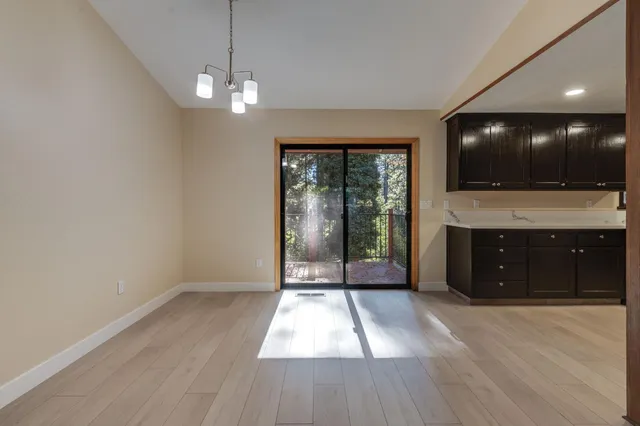 a view of a livingroom with a flat screen tv wooden floor and staircase