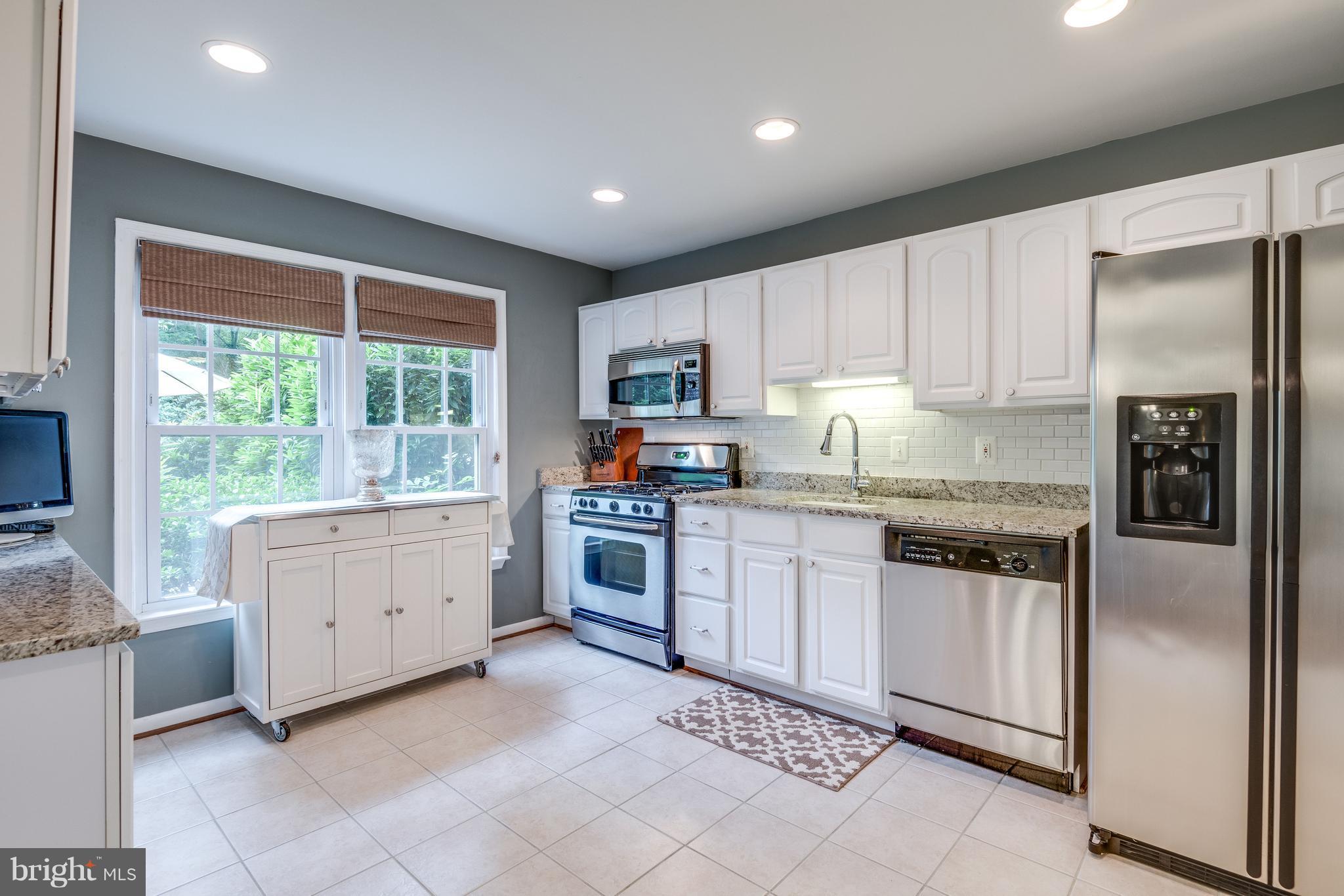 1804 Golf View Court Reston, VA 20190 - Photo 5 of 30 a kitchen with granite countertop white cabinets and white stainless steel appliances