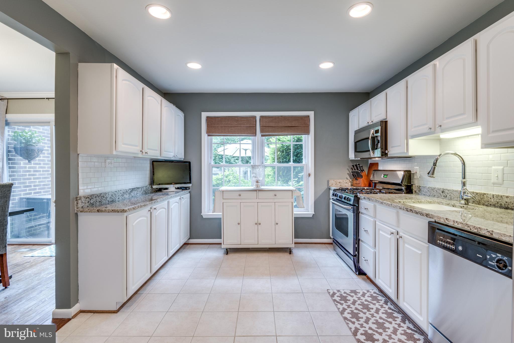 1804 Golf View Court Reston, VA 20190 - Photo 6 of 30 a kitchen with granite countertop a stove top oven sink and cabinets