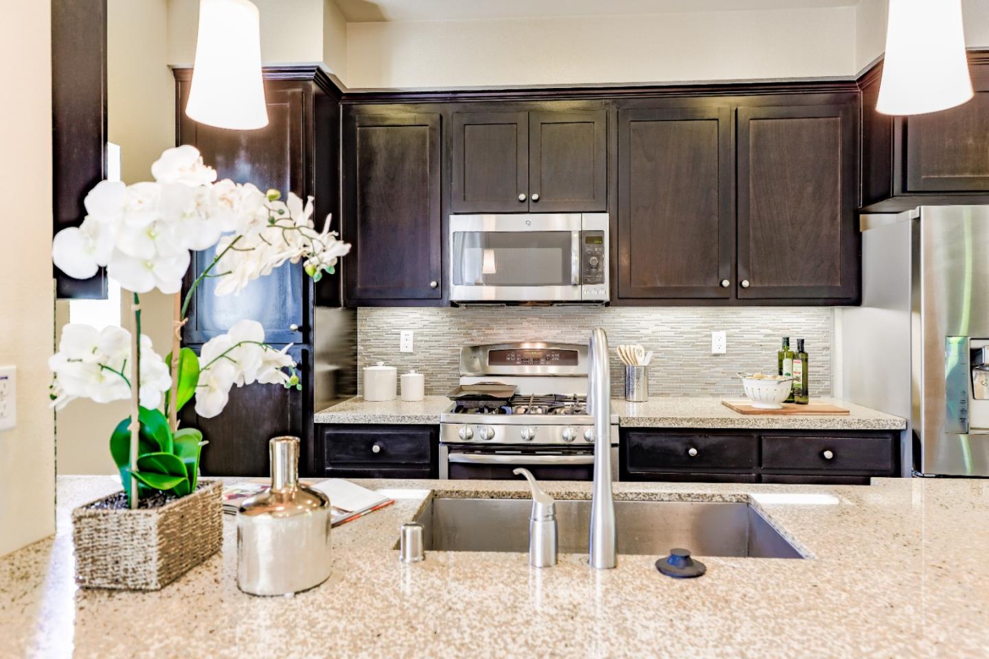 1095 Interlaken Terrace Sunnyvale, CA 94089 - Photo 7 of 25 a kitchen with stainless steel appliances kitchen island granite countertop a refrigerator a stove a sink and a white cabinets