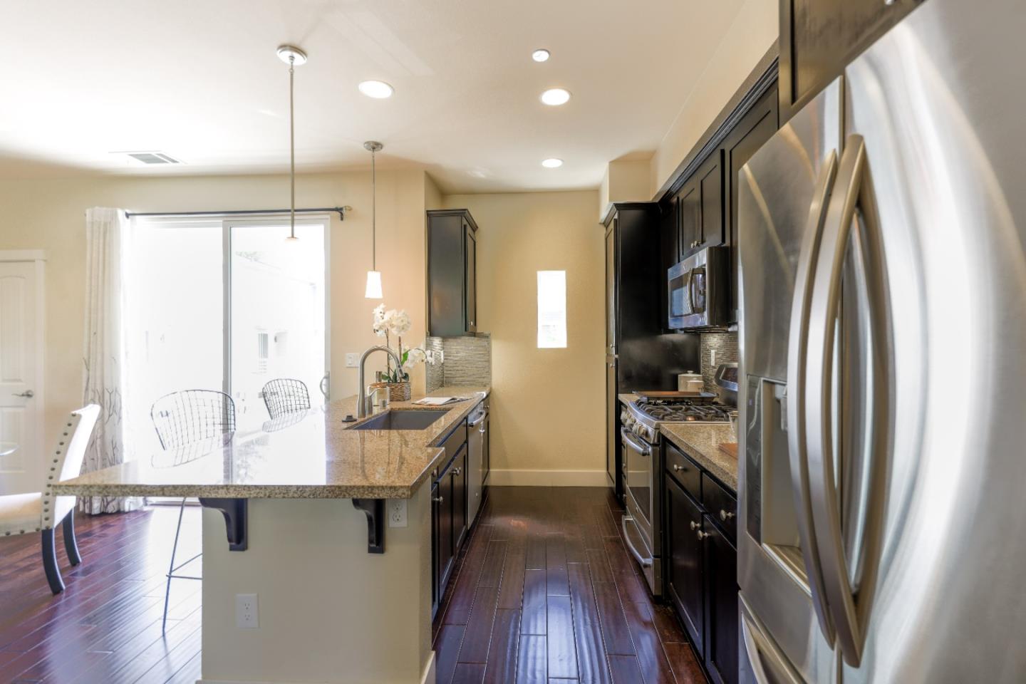 1095 Interlaken Terrace Sunnyvale, CA 94089 - Photo 8 of 25 a kitchen with stainless steel appliances granite countertop a refrigerator a stove and a wooden floors