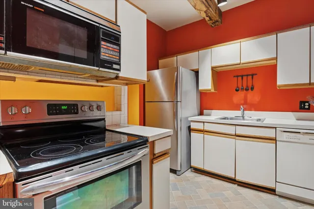 a kitchen with stainless steel appliances a stove a microwave and sink