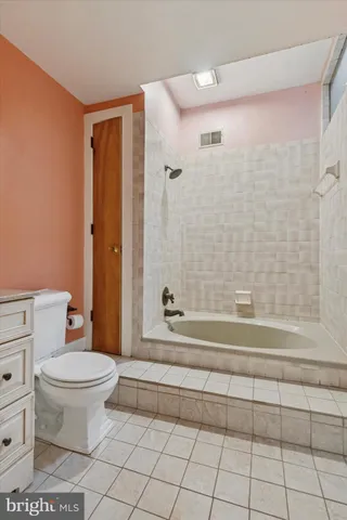 a bathroom with a toilet a sink a vanity and mirror