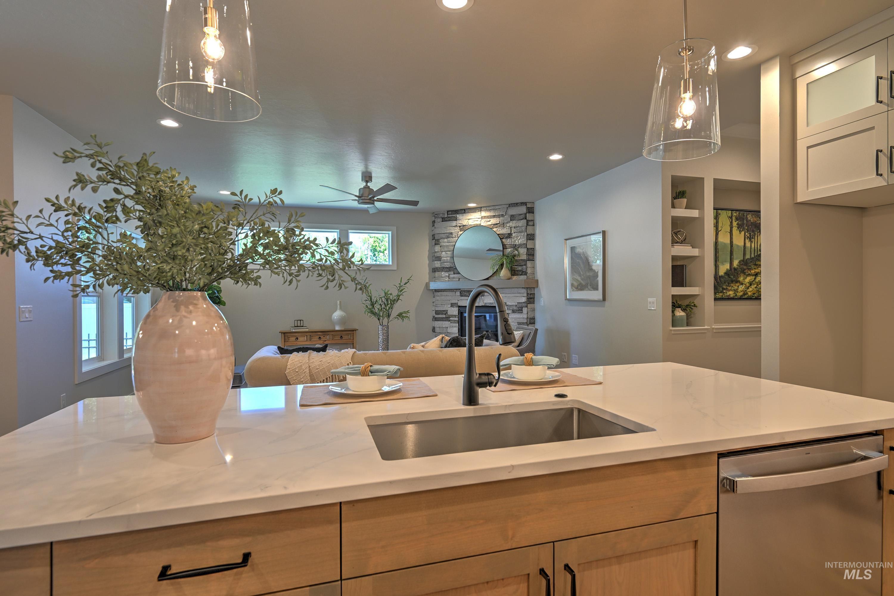 1469 North Parkshire Way Meridian, ID 83642 - Photo 42 of 43 Kitchen with stainless steel dishwasher, open floor plan, recessed lighting, a stone fireplace, and light stone countertops