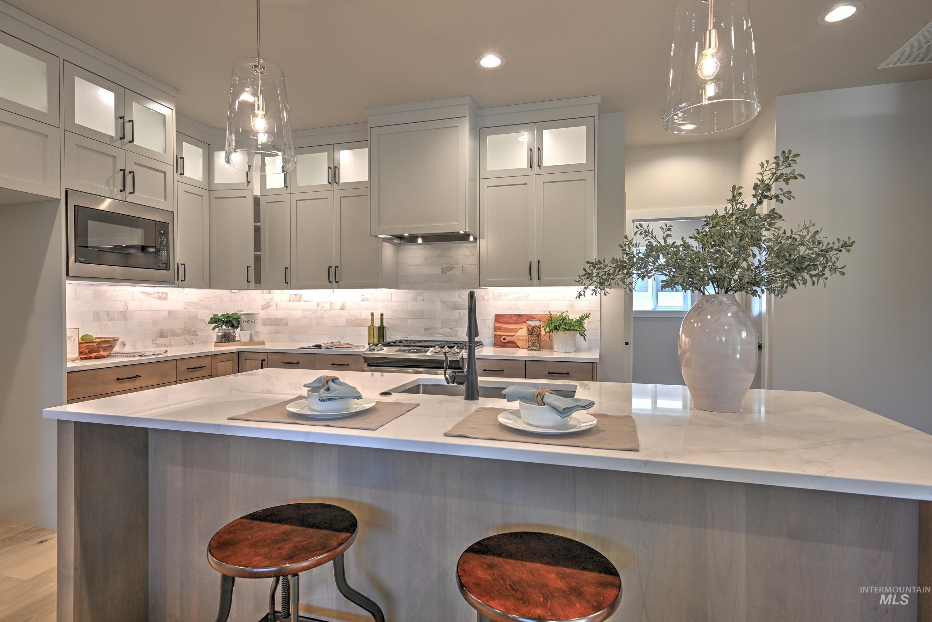 1469 North Parkshire Way Meridian, ID 83642 - Photo 19 of 43 Kitchen with black microwave, light stone counters, decorative backsplash, recessed lighting, and pendant lighting