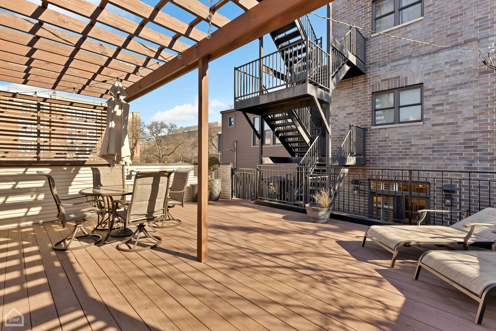 2242 North Seminary Avenue, Unit 1 Chicago, IL 60614 - Photo 31 of 37 a view of a patio with couches table and chairs with wooden floor and fence