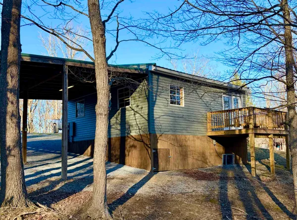a view of a house with backyard and trees