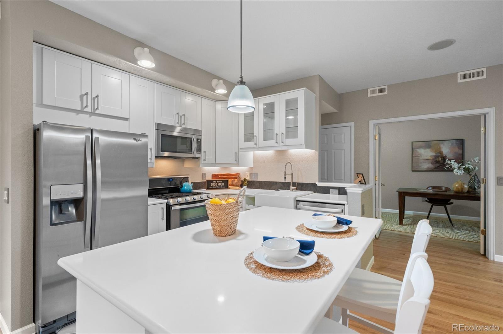 4501 Nelson Road, Unit 2104 Longmont, CO 80503 - Photo 6 of 29 a kitchen with a refrigerator a stove a dining table and chairs