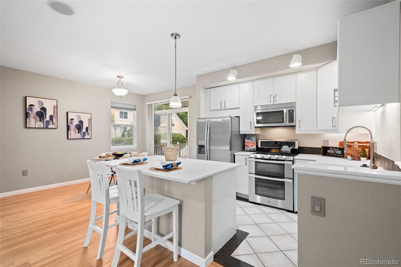 4501 Nelson Road, Unit 2104 Longmont, CO 80503 - Photo 7 of 29 a kitchen with stainless steel appliances kitchen island granite countertop a sink a stove a dining table and chairs