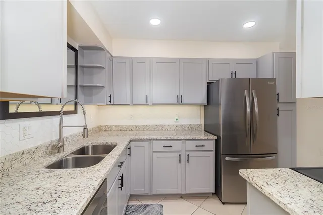 a kitchen with stainless steel appliances granite countertop a refrigerator and a sink