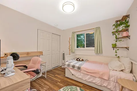 a bedroom with a bed and wooden floor