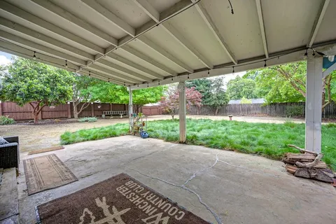 a view of a patio with a table and chairs under a large umbrella