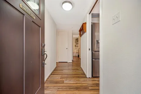 a view of a hallway with wooden floor and staircase