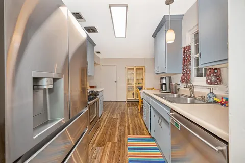 a kitchen with sink cabinets and stainless steel appliances