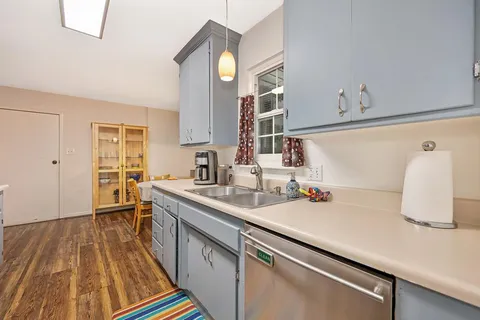 a kitchen with a sink and a wooden floor