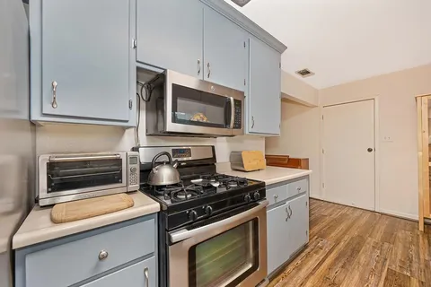 a kitchen with cabinets appliances and a wooden floor