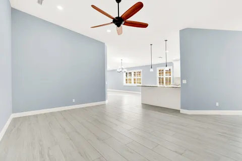 a view of a kitchen with wooden floor and a ceiling fan