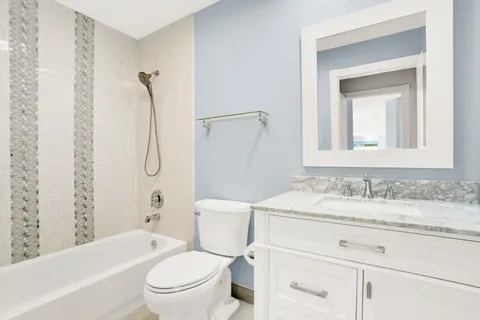 a bathroom with a sink toilet vanity and shower