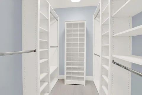 a view of walk in closet with empty racks