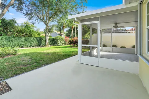 a view of a house with a big yard potted plants and large tree