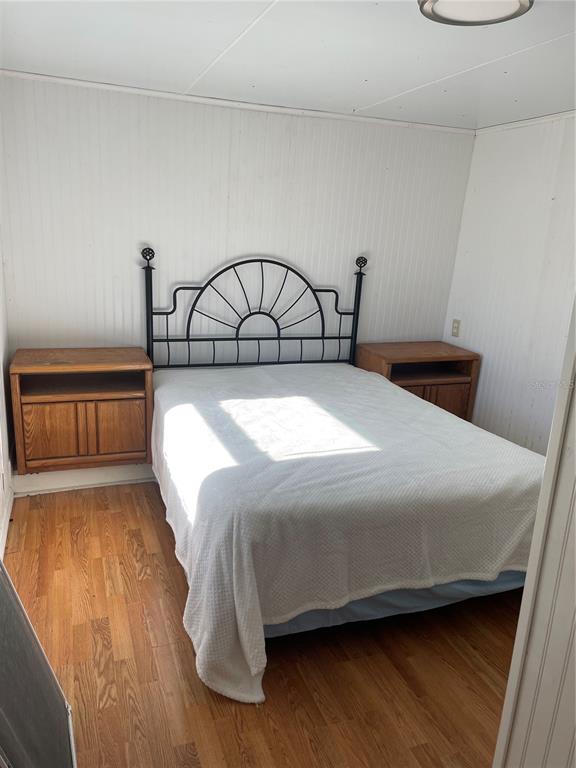 6275 Highway 441 Okeechobee, FL 34974 - Photo 13 of 18 a bed sitting in a bedroom next to a window with wooden floor