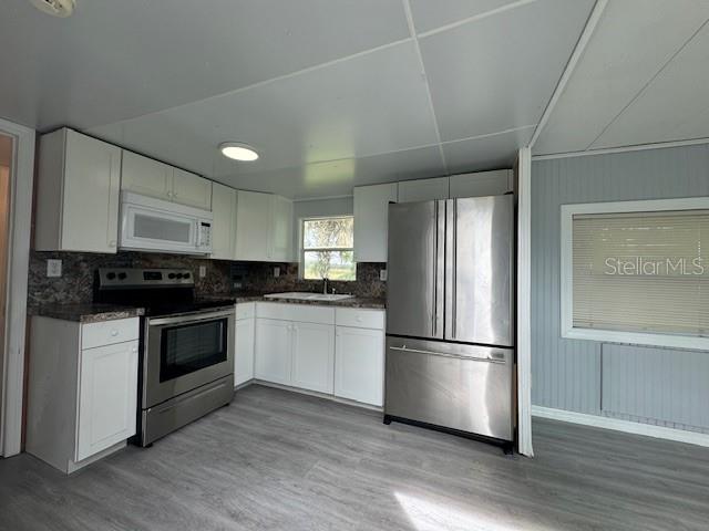 6275 Highway 441 Okeechobee, FL 34974 - Photo 2 of 18 a kitchen with a refrigerator and white cabinets