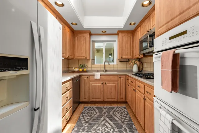 a kitchen with stainless steel appliances granite countertop a refrigerator and a sink