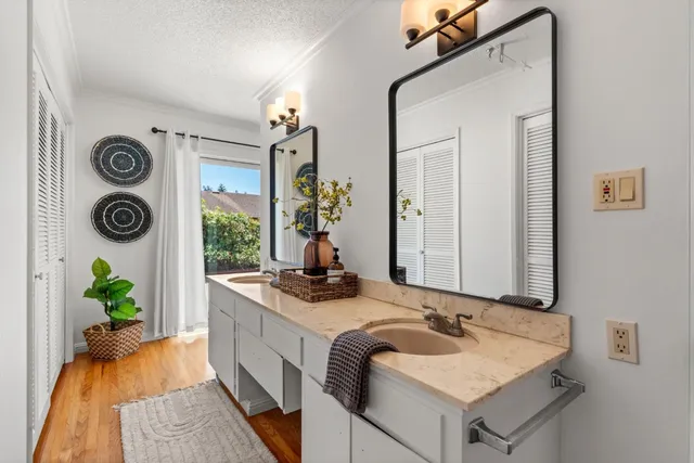 a en suite bathroom with a granite countertop sink and a mirror