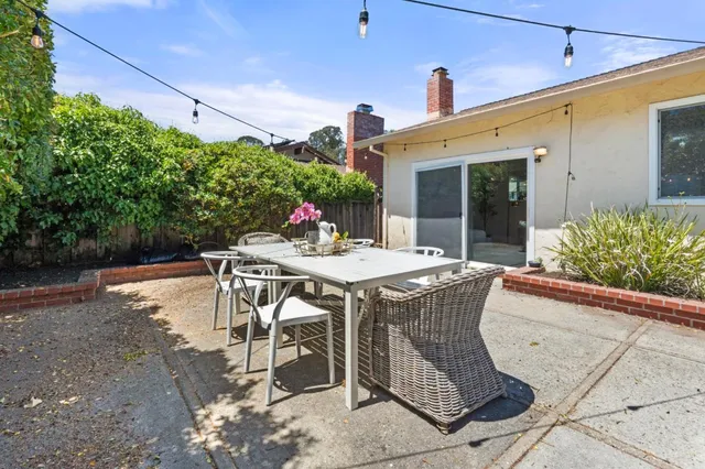 a view of a patio with table and chairs and potted plants