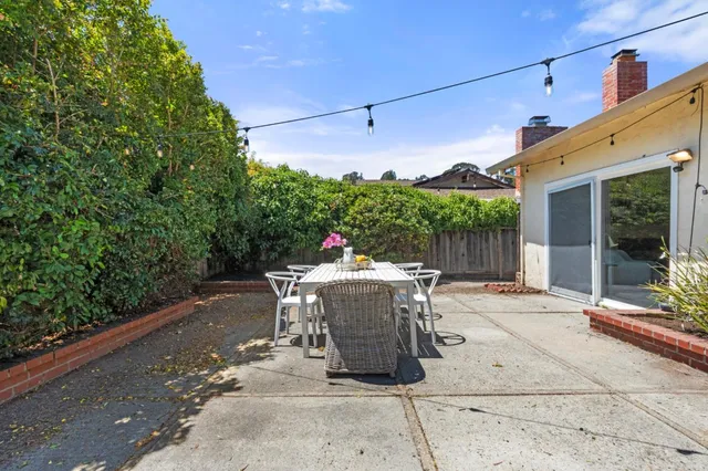 a view of a patio with a dining table and chairs