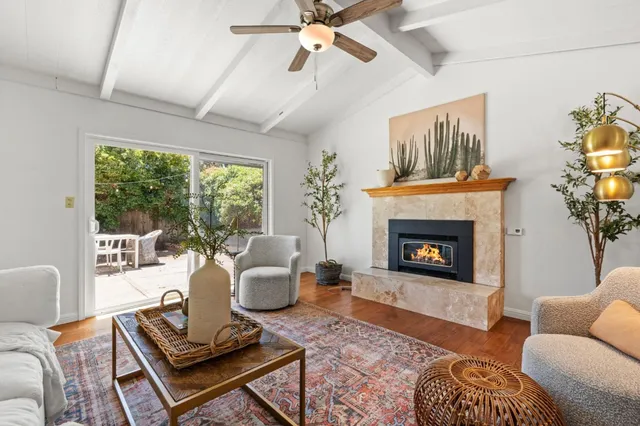 a living room with furniture fireplace and a large window