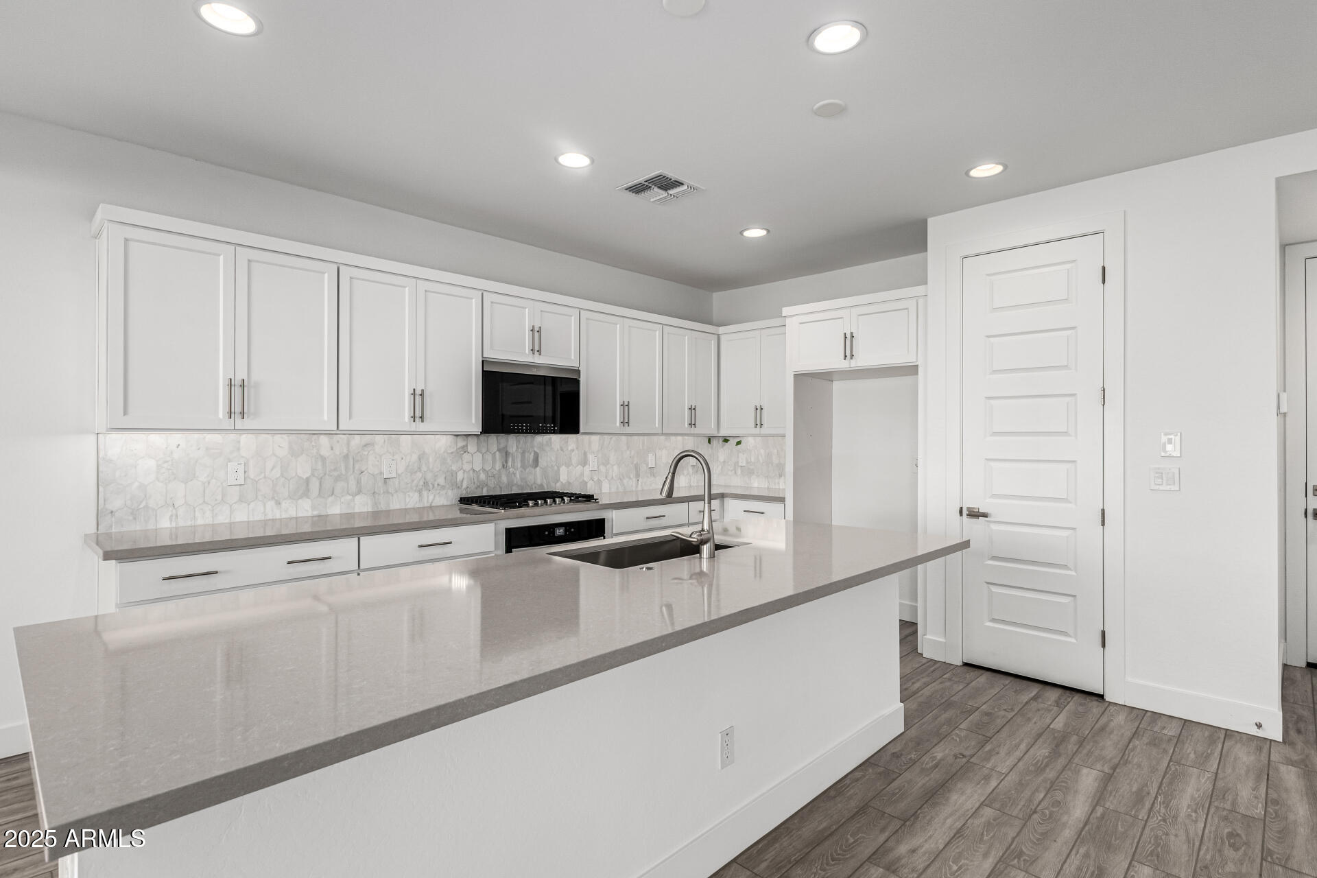 21494 East Timberline Road Queen Creek, AZ 85142 - Photo 11 of 32 a kitchen with white cabinets and stainless steel appliances