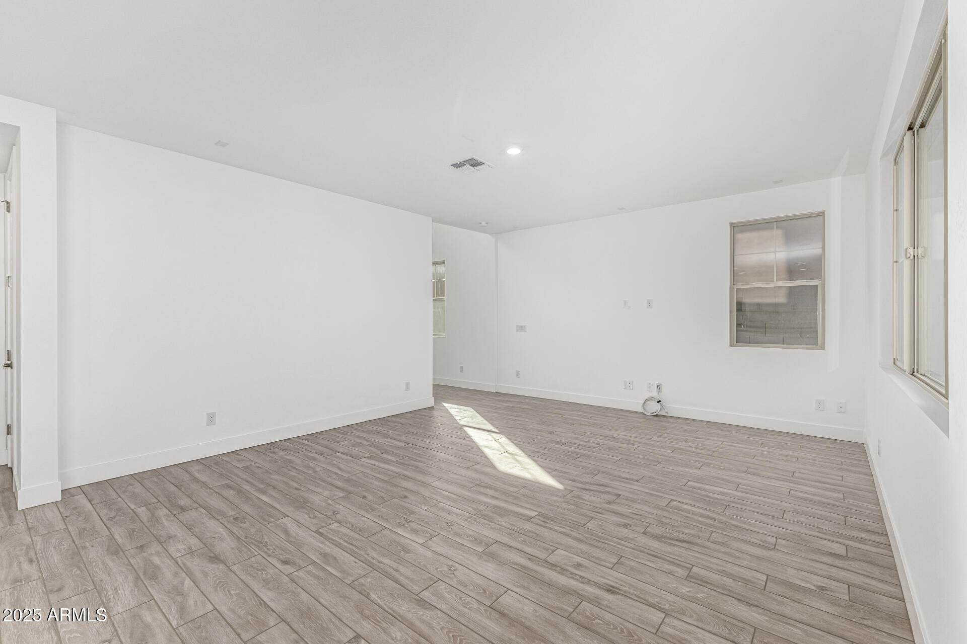 21494 East Timberline Road Queen Creek, AZ 85142 - Photo 7 of 32 a view of an empty room with wooden floor and a window