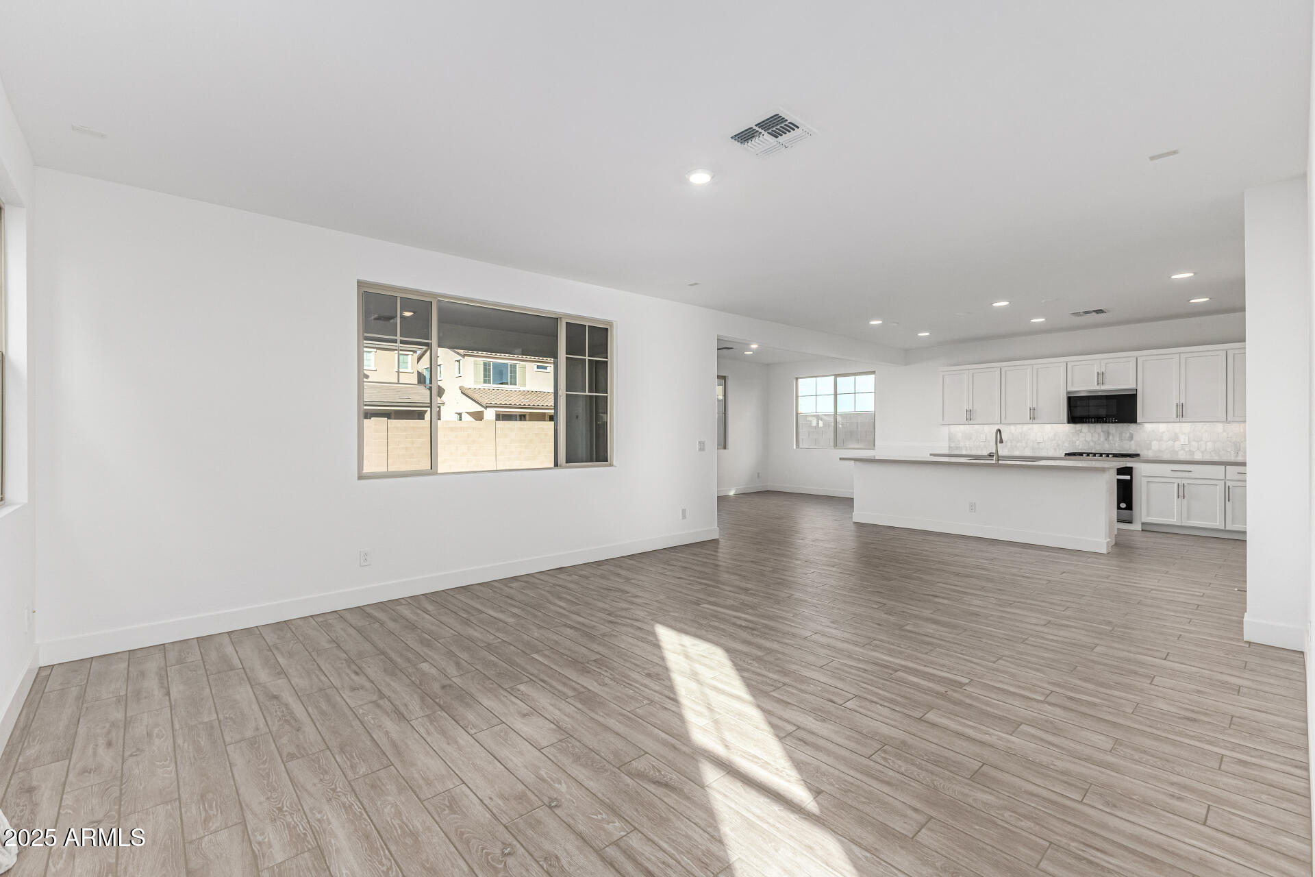 21494 East Timberline Road Queen Creek, AZ 85142 - Photo 8 of 32 a view of an empty room with wooden floor and a kitchen