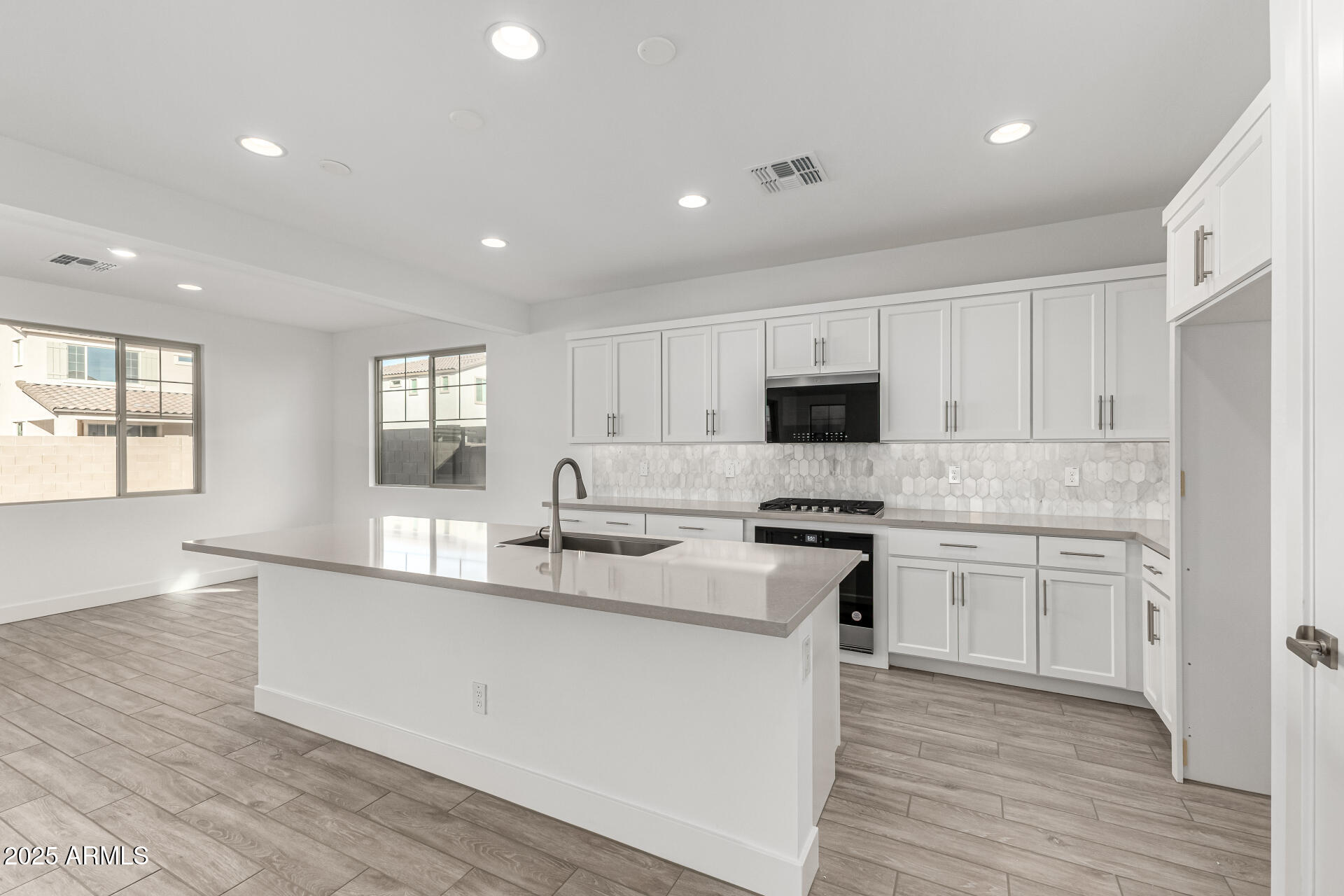 21494 East Timberline Road Queen Creek, AZ 85142 - Photo 10 of 32 a kitchen with stainless steel appliances granite countertop a stove a sink dishwasher a refrigerator and white cabinets with wooden floor