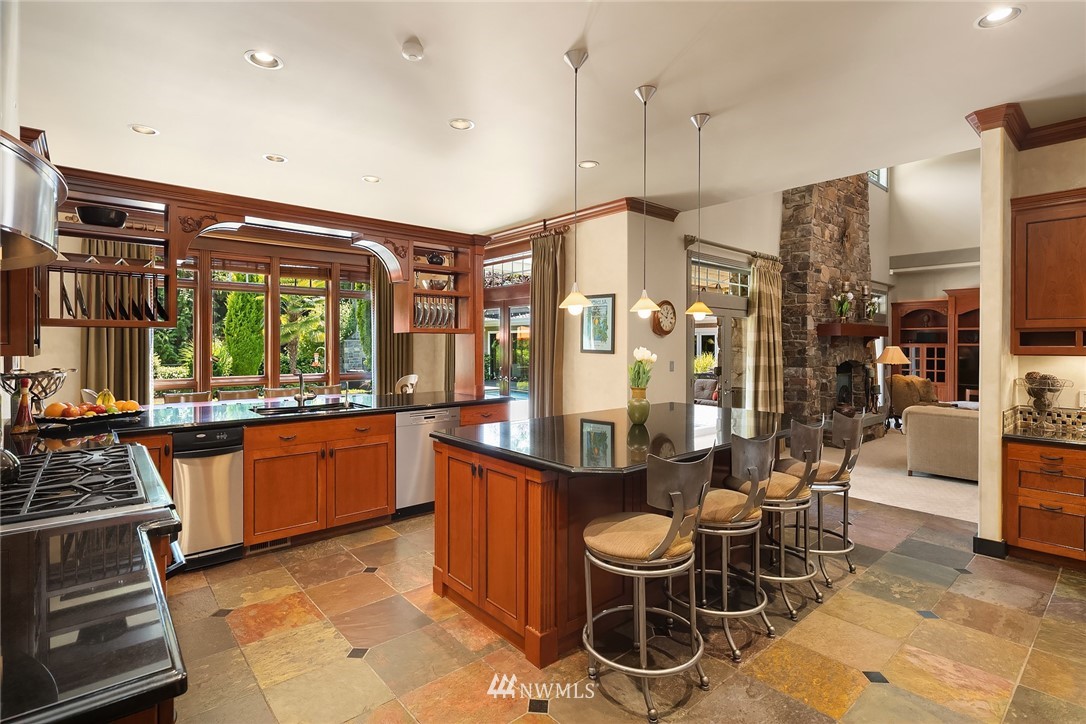 3114 220th Street Southeast Bothell, WA 98021 - Photo 15 of 39 a large kitchen with stainless steel appliances a stove a sink dishwasher and a dining table with granite countertops