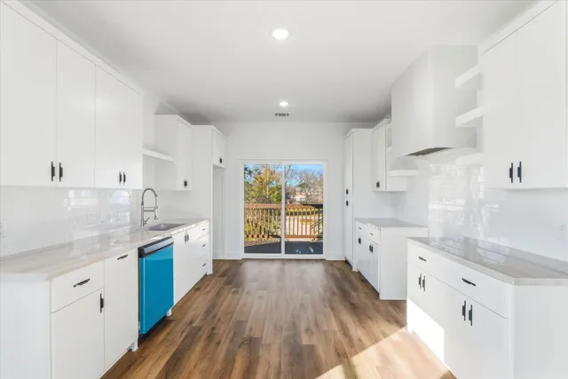 a large kitchen with cabinets wooden floor and stainless steel appliances