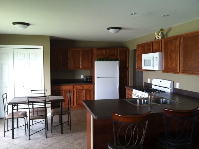 125 Cobblestone Court DeKalb, IL 60115 - Photo 5 of 25 a kitchen with granite countertop a table chairs a sink dishwasher refrigerator and cabinets