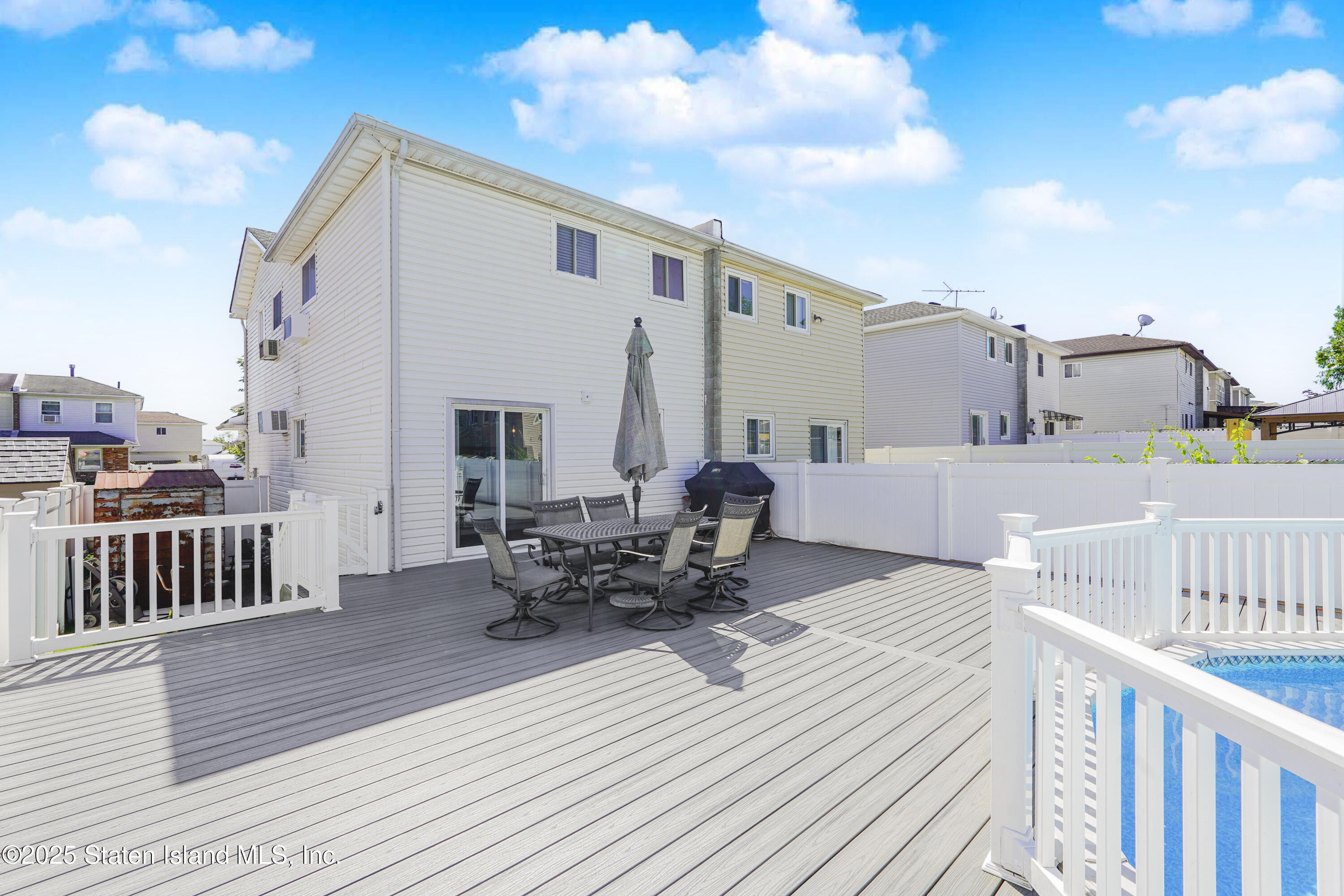 80 Gold Avenue Staten Island, NY 10312 - Photo 30 of 33 a view of a roof deck with table and chairs with wooden floor