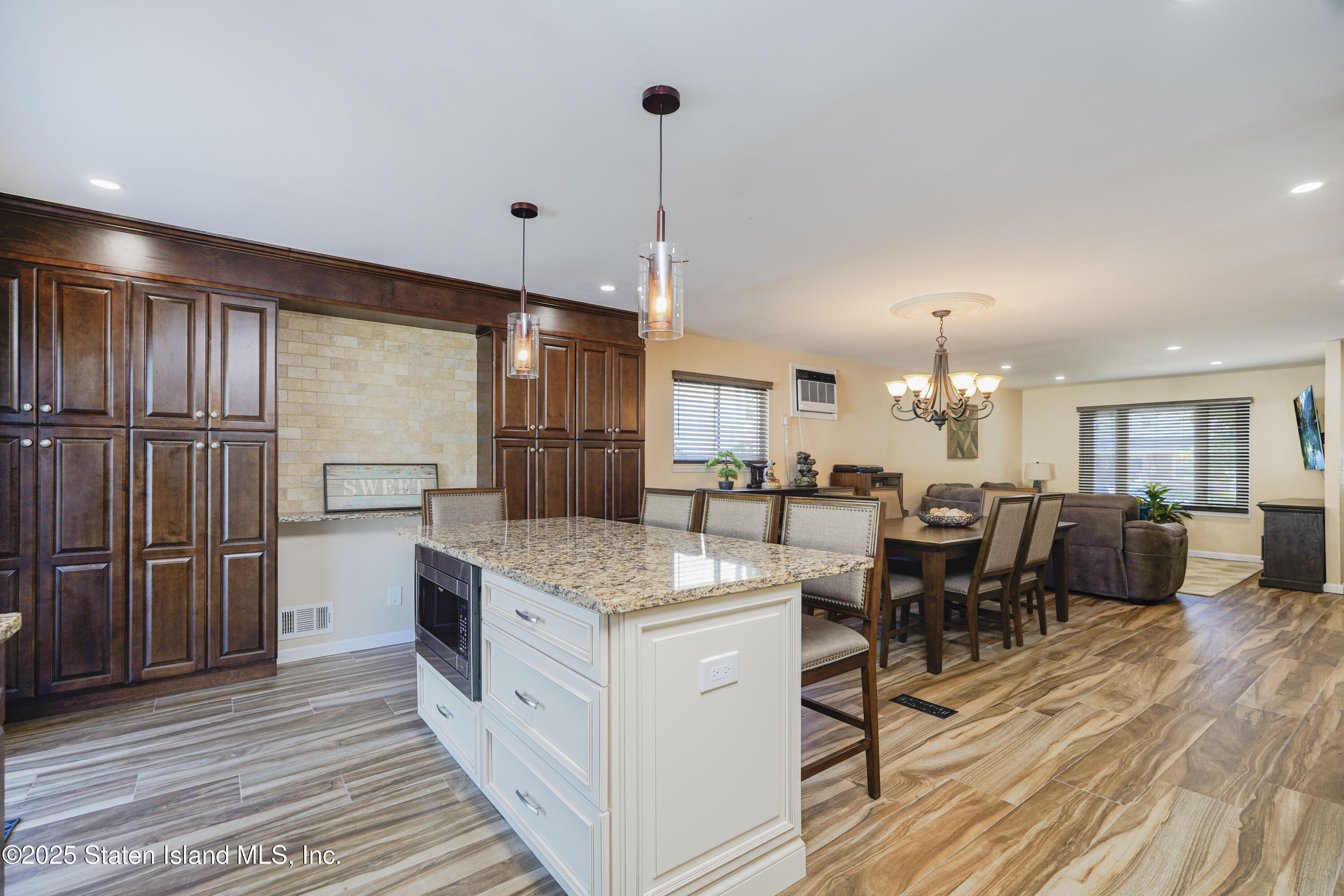 80 Gold Avenue Staten Island, NY 10312 - Photo 7 of 33 a kitchen with stainless steel appliances granite countertop a refrigerator a sink dishwasher a dining table and chairs with wooden floor