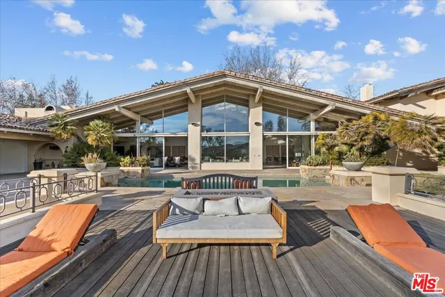 a view of a house with pool and sitting area