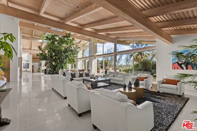 a living room with furniture and a floor to ceiling window