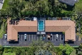 an aerial view of a house with balcony and trees all around
