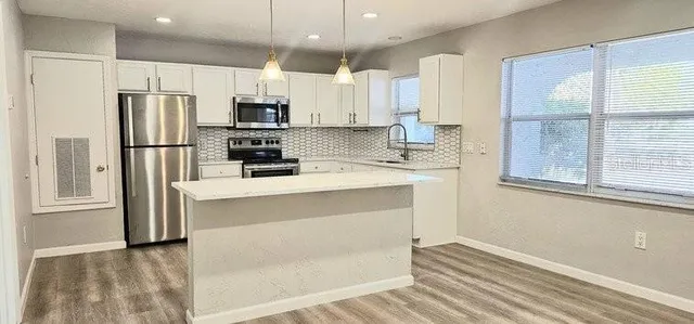 a kitchen with white cabinets and stainless steel appliances