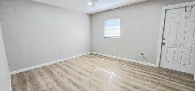 a view of empty room with wooden floor