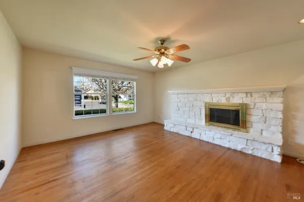 an empty room with windows and fireplace