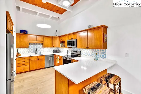 a kitchen with stainless steel appliances granite countertop a sink and dishwasher a stove with wooden floor