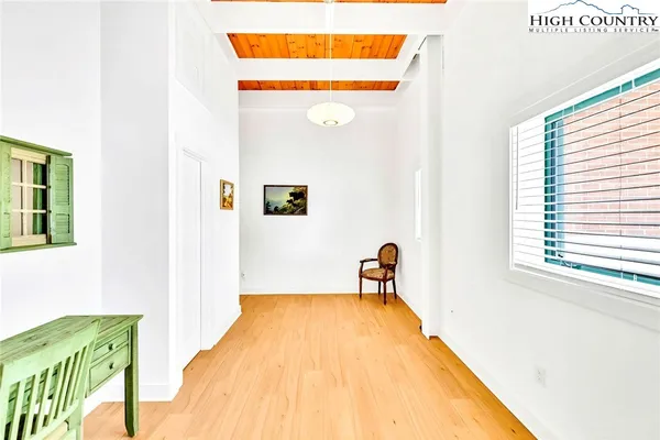 a view of a bedroom with wooden floor and a window