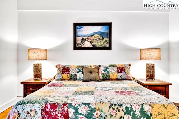 a bedroom with a bed and wooden floor